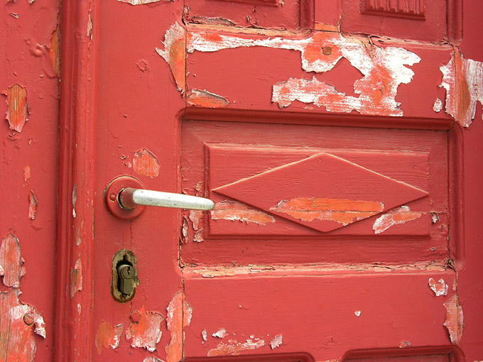 red orange door with flaking paint
